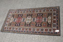 A British Wilton wool Runner rug, black/blue and red, geometric design 54" x 27 1/2".