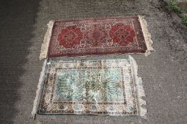 Two small rugs with fringing, one having a Shanghai hand knotted silk carpet rug label,