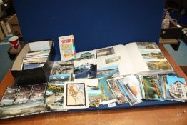 A quantity of postcards plus a photo album containing postcards.