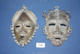 A pair of male and female African style face metal masks, 8 1/2'' x 5 1/2''.