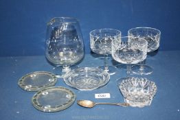 Three cut glass champagne glasses, a large unusual stemmed glass, coasters and a silver teaspoon.