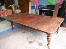 A circa 1900 Mahogany wind-out Dining Table, standing on turned legs with brass caster,
