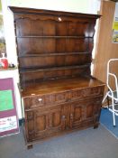 A Reproduction Oak Dresser with two drawers, two door cupboard below and having carved detail.