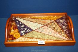 A treen tray with dried flowers under glass, 16 1/2'' x 10 1/4''.
