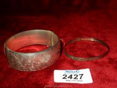 A silver bangle with hallmarks for Birmingham 1965, maker Smith & Pepper Ltd , with engraved front,