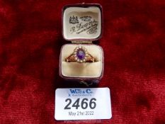 A maroon presentation cased 9 carat gold ladies ring set with a central oval Amethyst with a