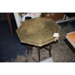 An octagonal Benares Table the brass top having engraved decoration, 24" x 24" x 22" tall.