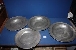 Four large pewter chargers; two made in Paris, one initialed F.A., 13" diameter approx.