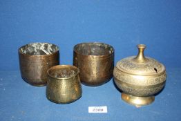 Three brass canisters with engraved decoration and one lidded pot.