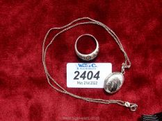 A vintage silver ring set 18 clear stones, stamped 925, plus an oval locket and chain, stamped 925.