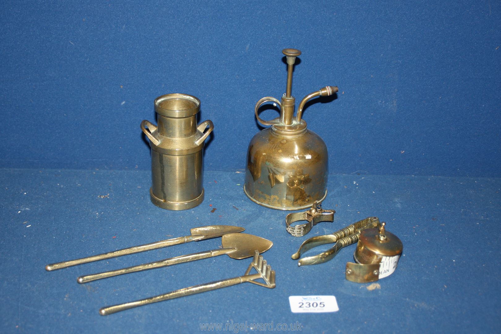 A miniature brass milk churn and contents of garden tools, brass measuring tape,