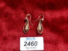 A pair of yellow metal swinging feature earrings.