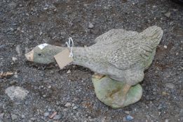 A concrete goose, (damaged beak).