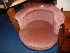 A pink/violet tub chair, one leg a/f.