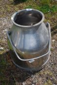 A stainless steel milk bucket.