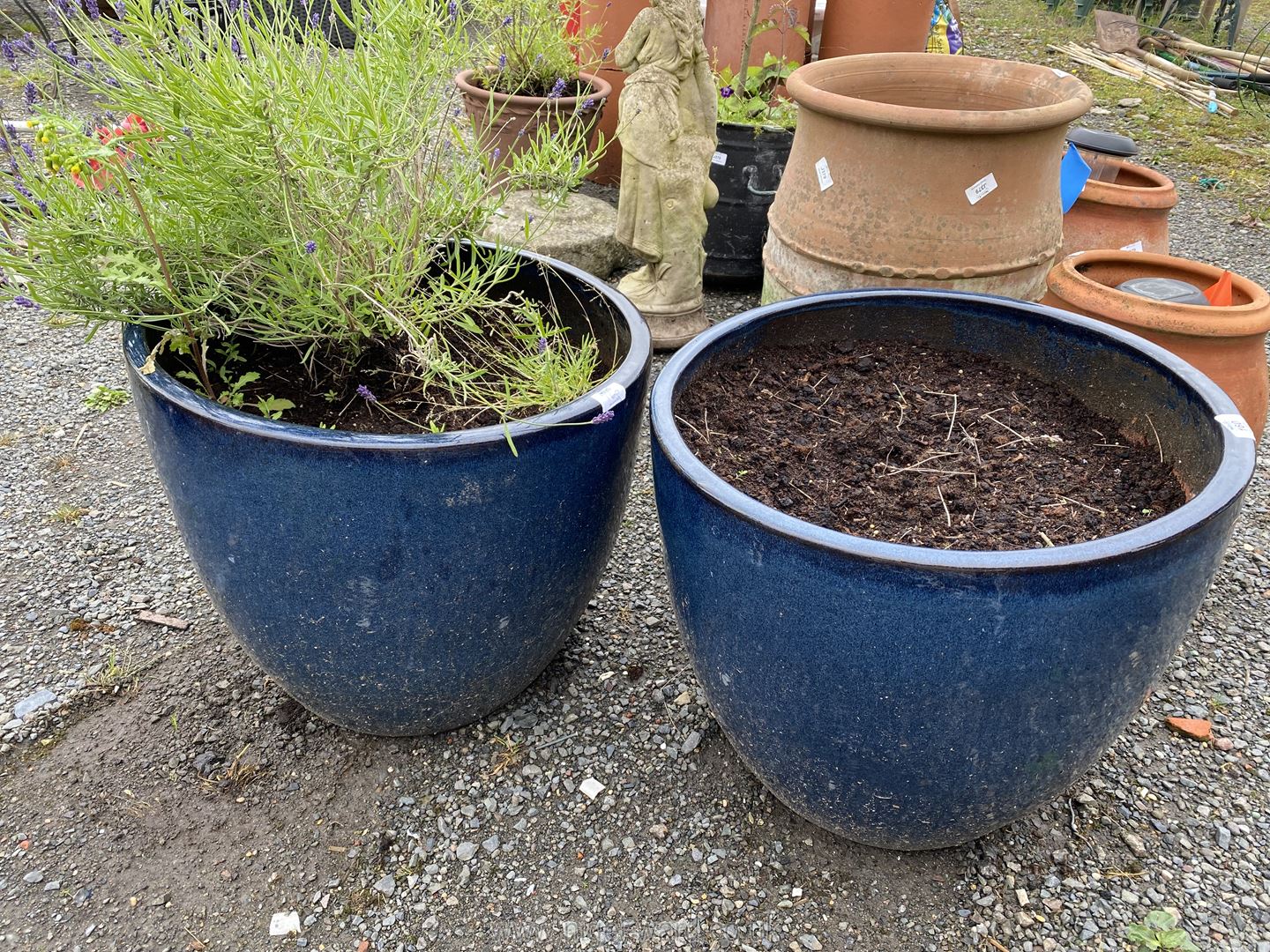 A pair of blue glazed Planters, 16" high x 15 1/2" diameter, one with lavender.