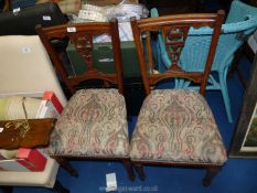 A pair of Mahogany hall chairs with carved and fretwork detail to the back.