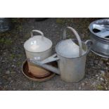 A galvanised drinker and watering can.