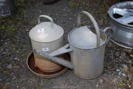 A galvanised drinker and watering can.