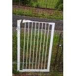 A white pet gate, 28" wide x 43" high.