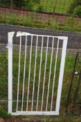 A white pet gate, 28" wide x 43" high.