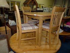 An extending pine table with four chairs.