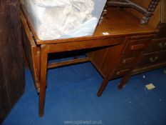 An oak desk with drop leaf end.