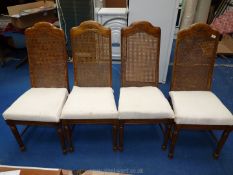 Four rattan backed dining chairs.