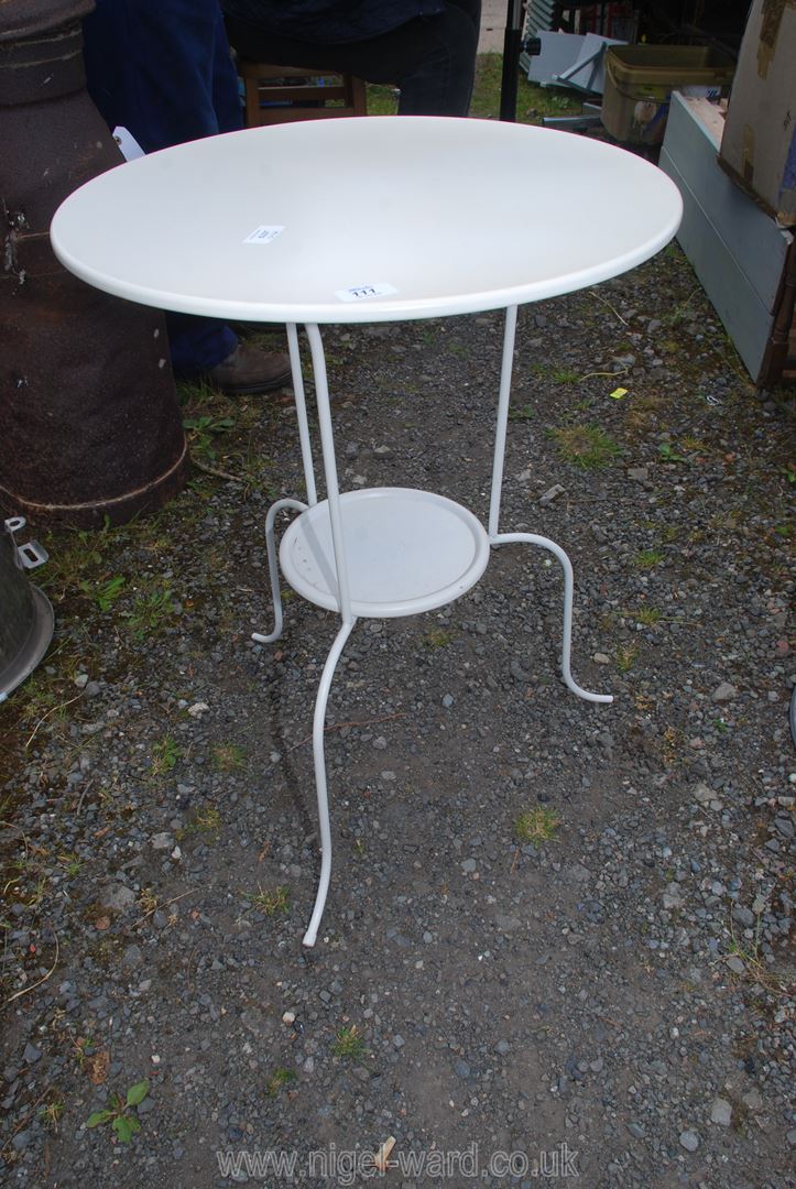 A cream painted circular metal table, 27" high x 20" diameter.