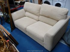 A beige two seater sofa.