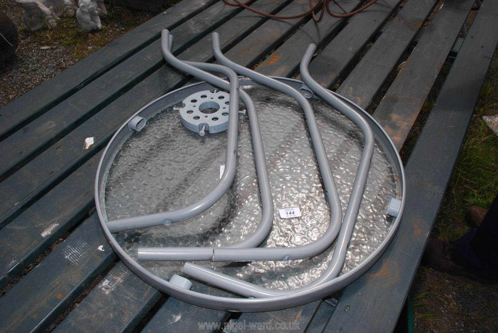 A flat pack circular table with glass top, 2' diameter.