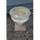 A concrete planter, 16" high x 15" diameter.