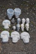 A quantity of garden concrete ornaments to include; two small dinosaur heads, skulls, etc.