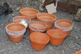 Eight terracotta flower pots.
