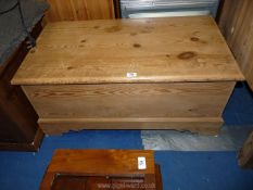 A stripped pine blanket box with contents.