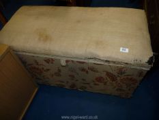 A fabric covered blanket box with candle compartment.