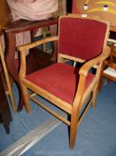 A lightwood show frame hall chair with red seat.