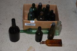 A quantity of green and brown glass bottles, some with stoppers.