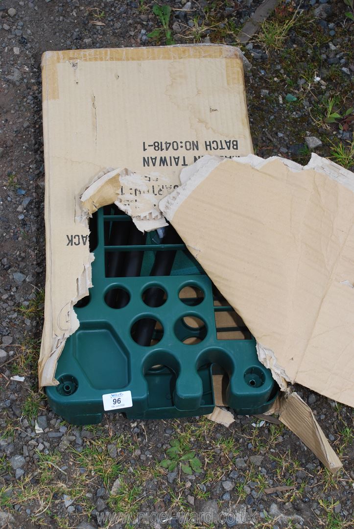 A green plastic garden tools rack.