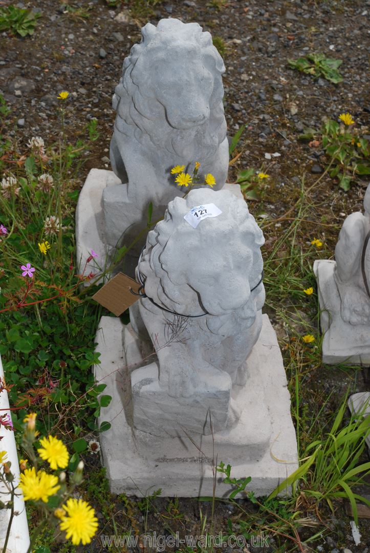 Two concrete heraldic lions with shields.