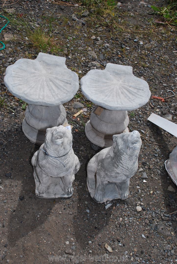 Two concrete wolves and two bird baths.