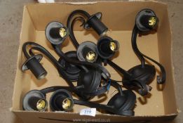 A box of four black metal wall lights.