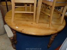 A pine circular table on four turned legs, 59" diameter.