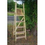 A five rung wooden step ladder painted in yellow.