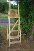 A five rung wooden step ladder painted in yellow.