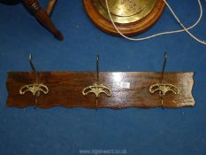 A wood and brass effect coat rack.