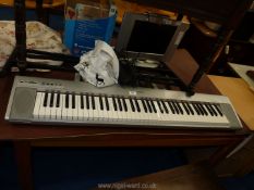 A portable 'Yamaha' grand keyboard with stand.