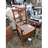 A satinwood framed open armed Commode Armchair having a caned seat,