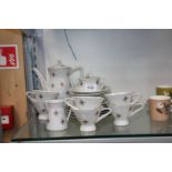 An Art Deco six setting Teaset in white with orange and gold pattern.