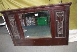 A bevel edged over mantel mirror having carved wooden frame and stylised flowers to side panels,